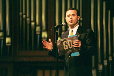 Todd Brady, campus minister, encourages students to <i>GO</i> during the GO Week Chapel Service 2002. - Photo by Justin Veneman