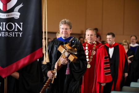 Mark Bolyard, faculty member of the year, bears the mace during the processional into Fall Convocation. - Photo by Kristi McMurry Woody