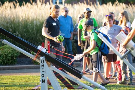 Gabriel Storm, engineering major, helps Family Weekend guests launch balls at the dunking booth during Union Night.  - Photo by Kristi McMurry Woody