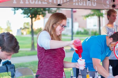 Emily Ebert, psychology major, makes snow cones for families and students attending Union Night. - Photo by Nikki Grim