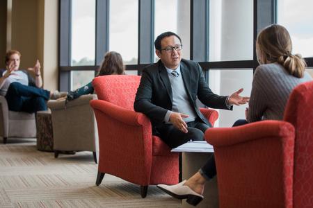 Joseph Xu, assistant professor of marketing, meets with a student in the library. - Photo by Kristi McMurry Woody