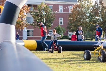 Jason Vaughan, director of development, and his family enjoy the activities during the Forever Bulldogs Homecoming event.  - Photo by Joey Echeverria