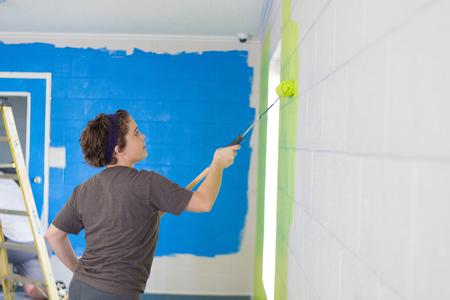 Kathleen Balon, economics major, helps paint at a church during Campus & Community Day. - Photo by Nikki Grim