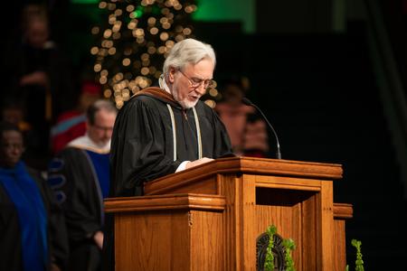 David Burke, professor of theatre, says the invocation at the beginning of Fall Commencement. - Photo by Kristi McMurry Woody