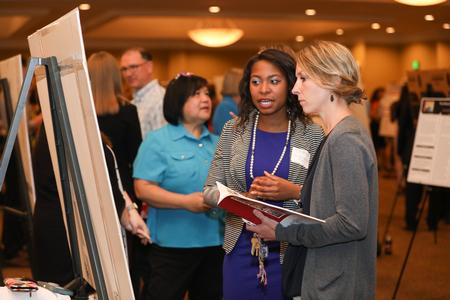Kim Jones, assistant dean for student services in the College of Pharmacy, looks at poster presentations during the annual Scholarship Symposium. - Photo by Kristi McMurry Woody
