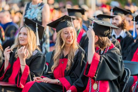 Madison Borden, pre-professional art therapy graduate, chats with her fellow graduates after receiving her diploma at spring graduation. - Photo by Kristi McMurry Woody