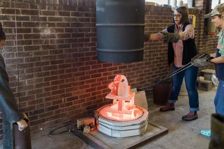 Ceramics students and Paige Ward, instructional staff, work on a raku firing. - Photo by Kristi McMurry Woody