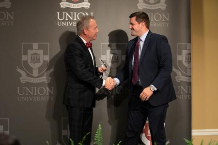 Dub Oliver, president of the university, presents AJ Massey with the Outstanding Young Alumni Award during Homecoming. - Photo by Kristi McMurry Woody