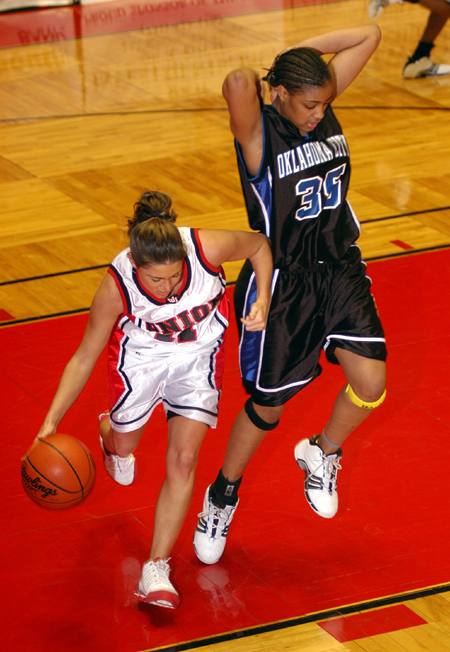 Jennifer Henson (11) attempts to dribble out of trouble in Union's win over Oklahoma City in the title game of the NAIA National Tournament. - Photo by Morris Abernathy