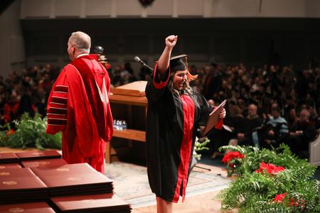 A graduate celebrates after receiving her diploma at fall graduation. - Photo by Kristi McMurry Woody