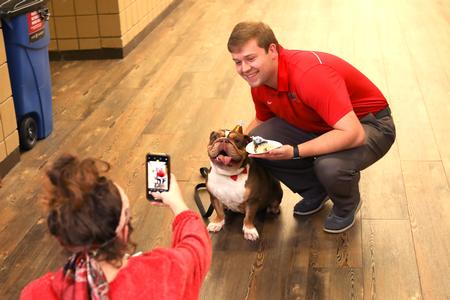 Luke McCormack, enrollment counselor, poses with Buster during a celebration of Buster's birthday. - Photo by Sarah Palmer Goff