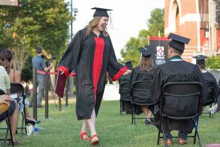 Caroline Clements, music education graduate, celebrates with her peers after receiving her diploma during Spring Commencement. - Photo by Kristi McMurry Woody