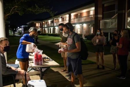 Katrina Bazzoli, residence director for the women's quads, serves snacks during Progressive Snacking. - Photo by Kristi McMurry Woody