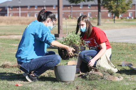 Students place a new plant on campus during Campus and Community Day.  - Photo by Sarah Palmer Goff