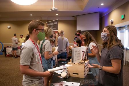 New students talk with representatives from Cardinal & Cream during the Welcome Week student life fair. - Photo by Joey Echeverria