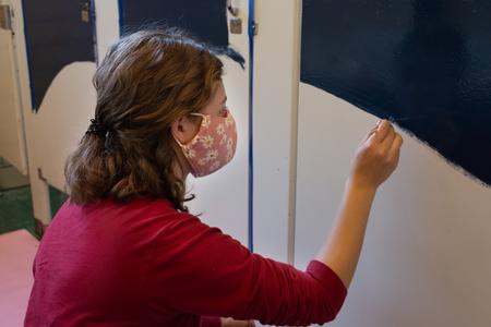 Students paint in a school bathroom during Campus and Community Day. - Photo by Naomi Mengel