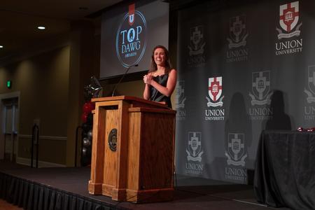 Delaney Sain, public relations major, presents awards at the Top Dawg Athletic Awards Banquet. - Photo by Kristi McMurry Woody
