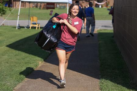 Emily Shoemaker, coordinator for service and events in University Ministries, helps new students move in. - Photo by Kristi McMurry Woody