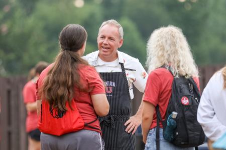 Dub Oliver, president of the university, greets new students at his home for an ice cream party during Welcome Week. - Photo by Kristi McMurry Woody