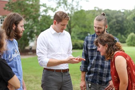 Jeremy Blaschke, associate professor of biology, talks with students about a reptile the department is caring for. - Photo by Kristi McMurry Woody