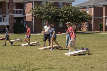 Students and their families enjoy a game of corn hole during Family Weekend. - Photo by Abigail Aspinwall