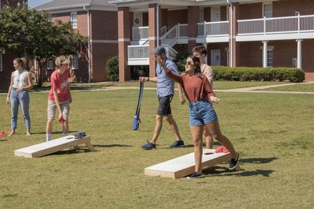 Students and their families enjoy a game of corn hole during Family Weekend. - Photo by Abigail Aspinwall