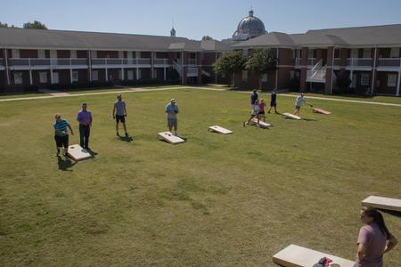 Students and their families enjoy a game of corn hole during Family Weekend. - Photo by Abigail Aspinwall