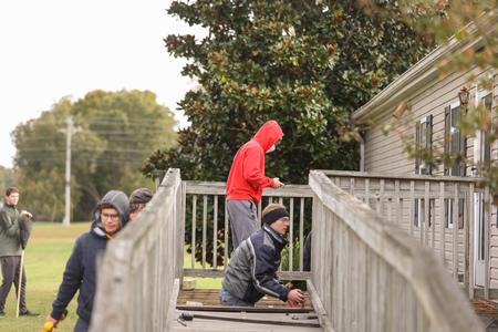 The men's golf team works on building a deck at Northbrook Church during Campus & Community Day. - Photo by Kristi McMurry Woody