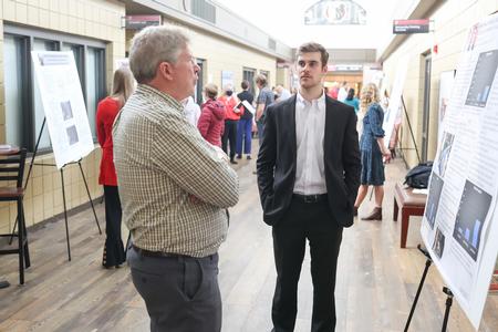 Mark Bolyard, university professor of biology and department chair, asks Grant Jacobs, cell and molecular biology major, about his research during the Fall Poster Sessions. - Photo by Kristi McMurry Woody
