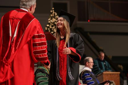 Emily Baer, psychology graduate, receives her diploma during Fall Commencement Services. - Photo by Kristi McMurry Woody