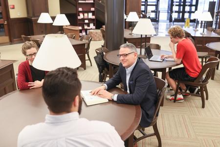 Keith Bates, professor of history, chats with students in the library. - Photo by Kristi McMurry Woody