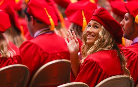 Mary Kate Woods, PharmD graduate, waves to her family and friends in the audience during spring graduation. - Photo by Suzanne Rhodes