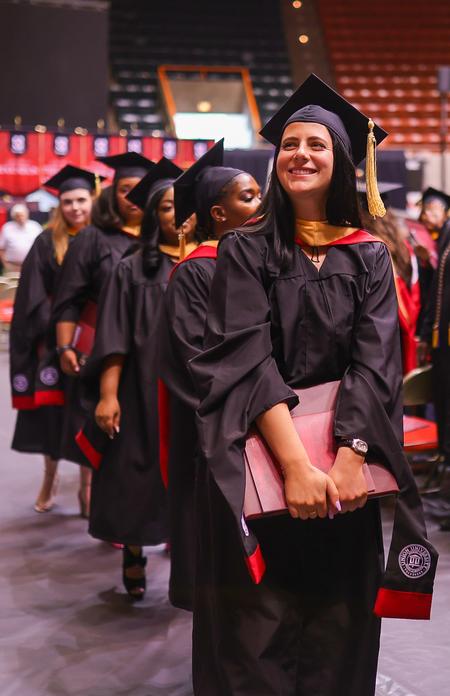 Olivia Johnston, MSW graduate, smiles to her family and friends as she receives her diploma at spring graduation. - Photo by Suzanne Rhodes