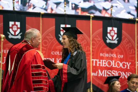 Mary Vranyes, business graduate, receives her diploma from President Dub Oliver at spring graduation. - Photo by Kristi McMurry Woody