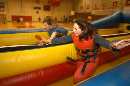 Enrollment Counslers Nikki Castles and Lisa Whiffen try out one of the inflatable games before the incoming freshman come and play during the Spring Thing weekend.  - Photo by Morris Abernathy