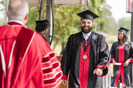 Christopher David Ballard, an MCUTS urban theological studies major from Bartlett, Tenn., walks across the stage to receive his diploma from President Oliver during Spring Graduation. - Photo by Kristi McMurry Woody