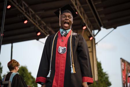 Steve Williams, a business administration major from Memphis, Tenn., celebrates as he crosses the stage at Spring Graduation. - Photo by Kristi McMurry Woody