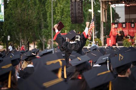 A graduate celebrates after receiving his diploma at Spring Graduation. - Photo by Kristi McMurry Woody