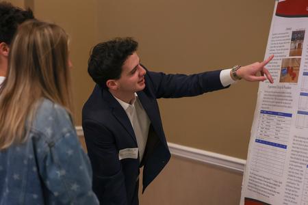Engineering major Philip J. Becker describes one of his three poster presentations at the 2023 UUSS. This poster was entitled "Maximizing Basketball Shooting Accuracy." - Photo by Eli Creasy