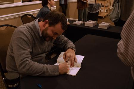 Union Alumnus Graham Hillard signs his book, Wolf Intervals: Poems, at the Department of English's annual Creative Writing Workshop. - Photo by Abigail Aspinwall