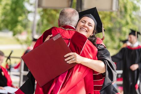 MBA graduate Brittany Boswell receives a hug from President Oliver during Spring Graduation. - Photo by Kristi McMurry Woody