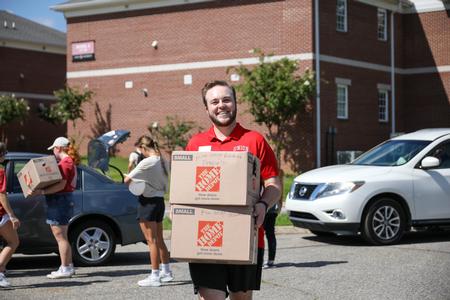 8/17/23 - Trenton Holloway, assistant director for the Vocatio Center, carries boxes in for a student on Move-In Day. - Karley Hathcock