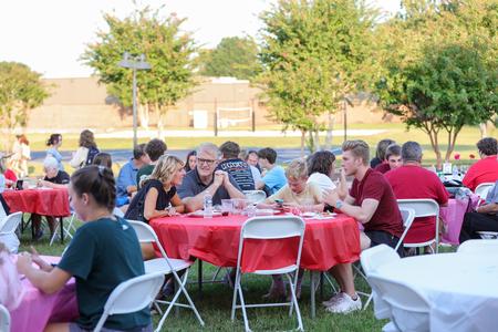 Families enjoy dinner at the Make-A-Wish BBQ hosted by the women of Chi Omega during Family Weekend. - Photo by Karley Hathcock