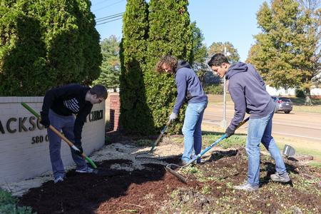 10/31/23 - Professor Matthew Albanese works with students on clearing out a flower bed at West Jackson Baptist Church for Campus and Community Day. - Karley Hathcock