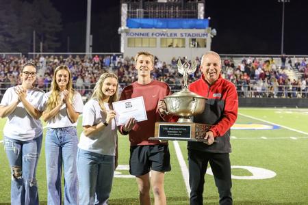 Students with the homecoming committee present Lambda Chi Alpha with the Homecoming Cup award during the Buster Bowl. - Photo by Karley Hathcock