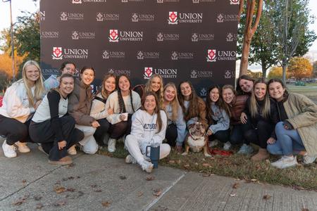 The women of Chi Omega take a photo with Buster (the second) at his retirement party during Homecoming 2023. - Photo by Lauren Steed
