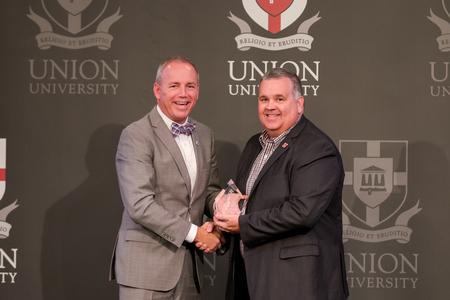 Clay Hallmark, senior pastor of First Baptist Church in Lexington, Tenn. and TBC president, receives the Alumnus of the Year Award from President Oliver at the Meritorious Service Awards Banquet during Homecoming Week. - Photo by Karley Hathcock