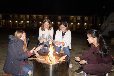 A group of Union students sit around a fire pit and roast marshmallows at the Homecoming kickoff event Fright Night. - Photo by Abigail Aspinwall