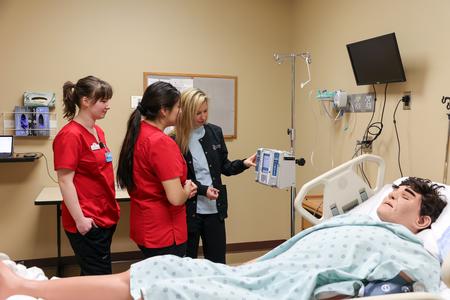 11/8/23 - Shayla Alexander, assistant professor of nursing, teaches students how to use an IV infusion pump during a simulation lab. - Karley Hathcock