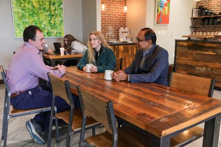 Santhosh Abraham, professor of accounting, meets with students in Modero.  - Photo by Karley Hathcock
